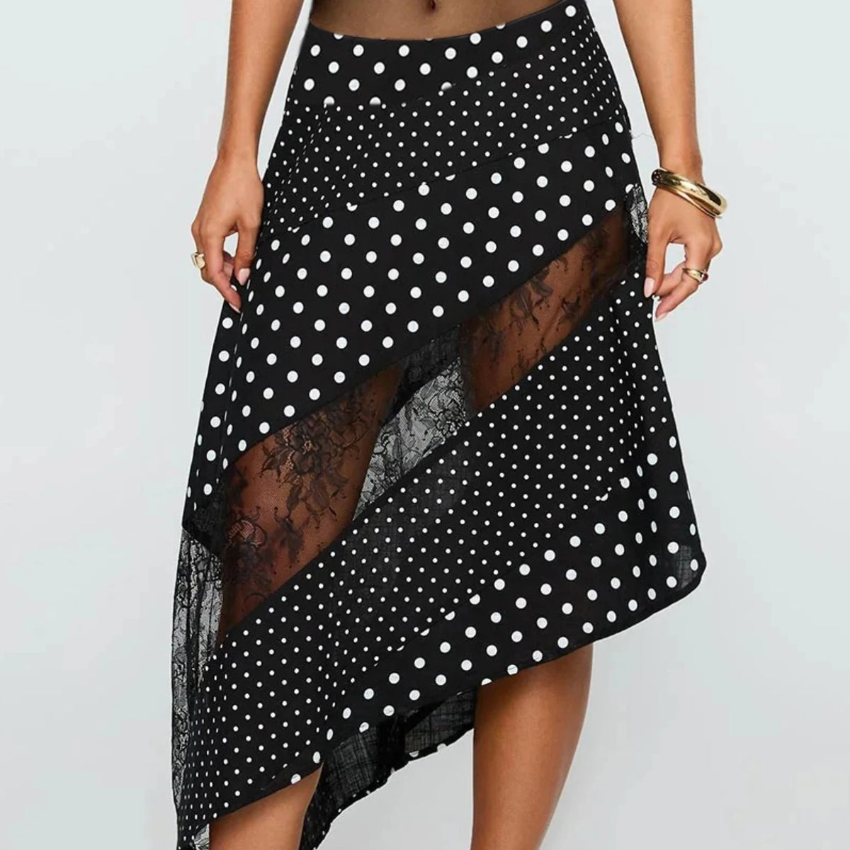 White women's midi flowy lace skirt with irregular hem, styled for a feminine and elegant look.