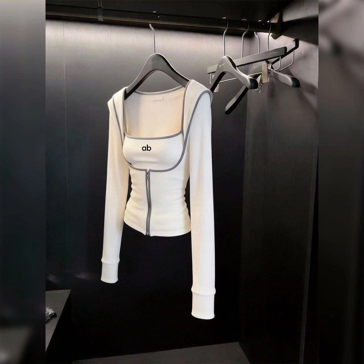 White 2-piece women's yoga set with cardigan, from Corporación Turística, shown with the cardigan draped over the matching activewear.