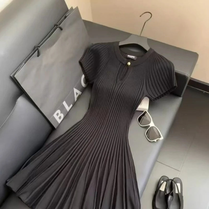 Elegant black knit dress by Corporación Turística, featuring a stylish and modern design, worn by a model in the image.