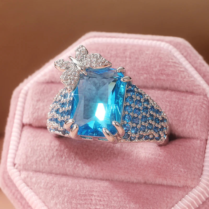 Elegant blue topaz cocktail ring featuring a butterfly design, crafted by Corporación Turística, showcasing intricate silver detailing.