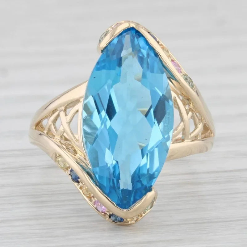 Elegant blue topaz cocktail ring by Butterfly featuring a detailed butterfly design, set in a luxurious gold band.