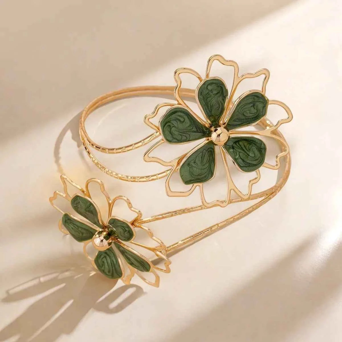 Open multicolored floral cuff bracelet by Corporación Turística featuring hollow flower designs on polished metal.