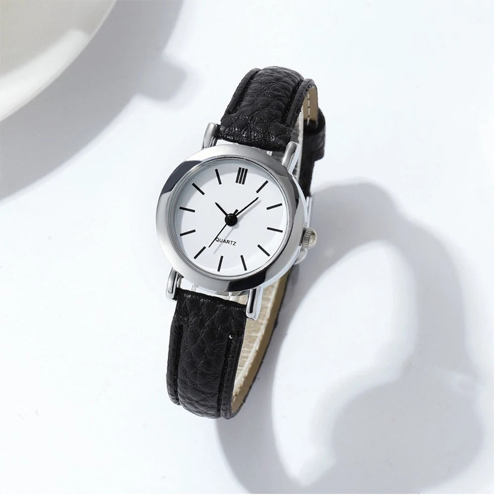 Minimalist white dial AAAMinimalist women's quartz watch by Corporación Turística with a sleek brown strap.