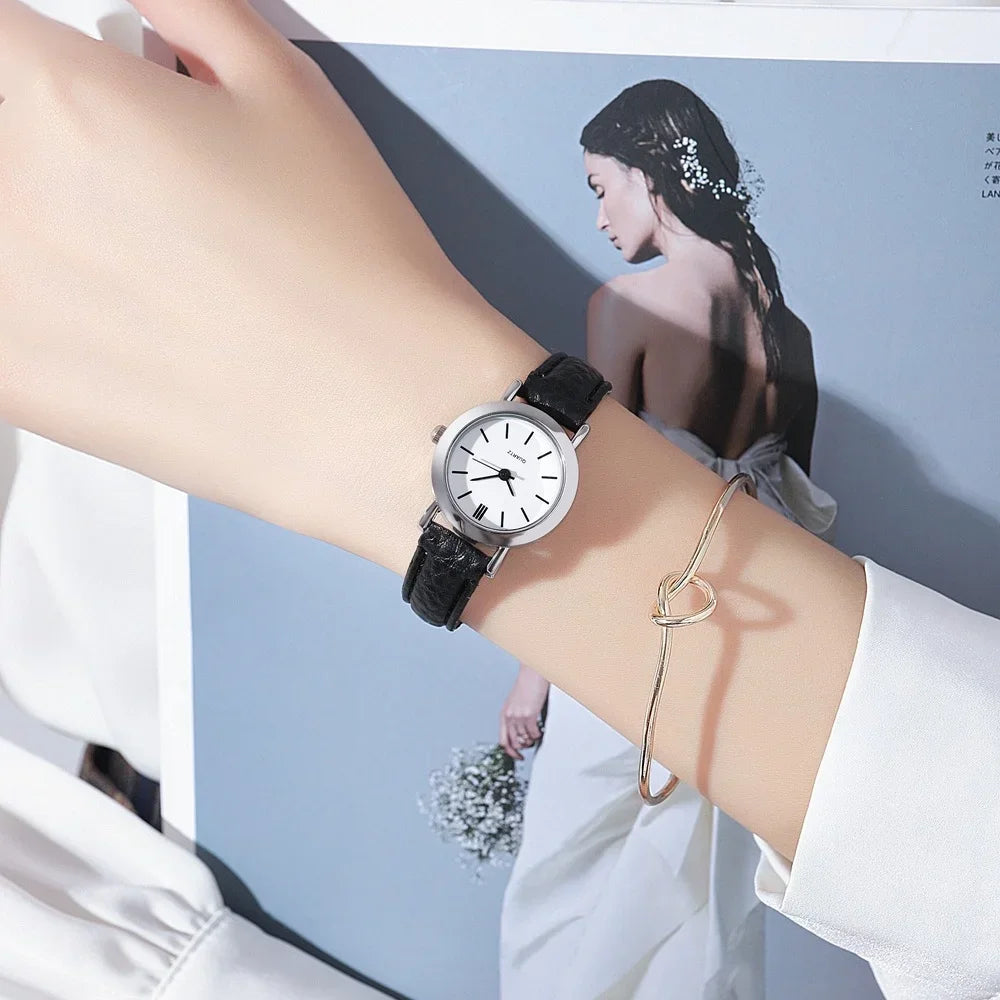 Minimalist women's quartz watch with white dial and brown strap by Corporación Turística, stylish and elegant timepiece.