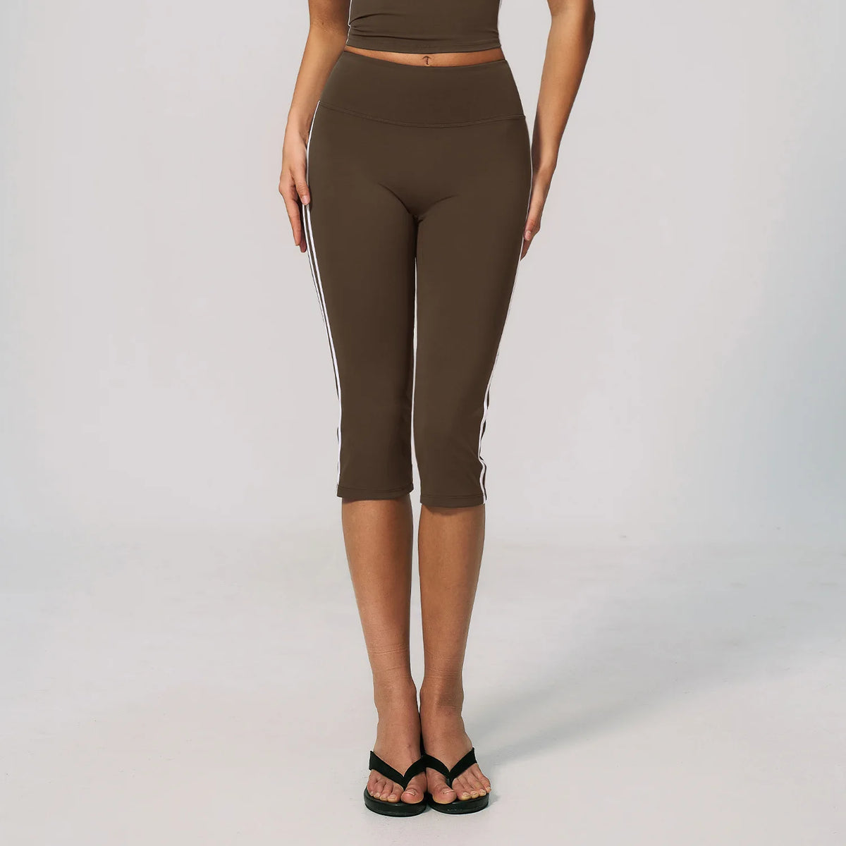 High-waisted women's sports shorts in burnt coffee color for cycling, branded by Corporación Turística, shown on a plain background.