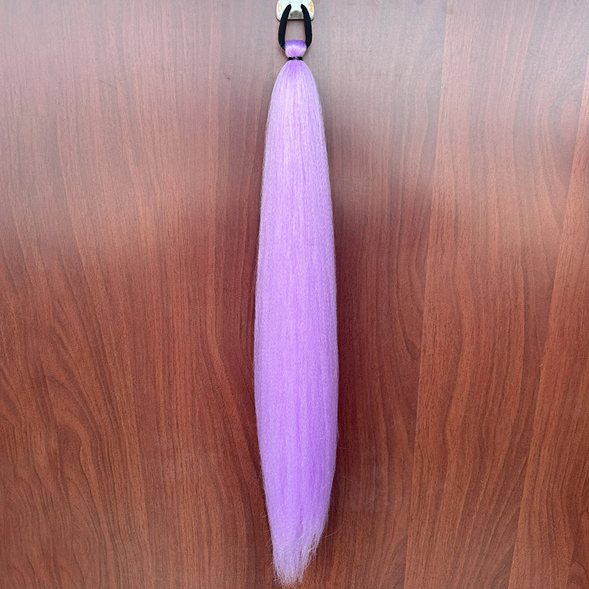 Purple synthetic ponytail extension with band, 26-28 inches, by Corporación Turística, showing the hair attached to a headband.