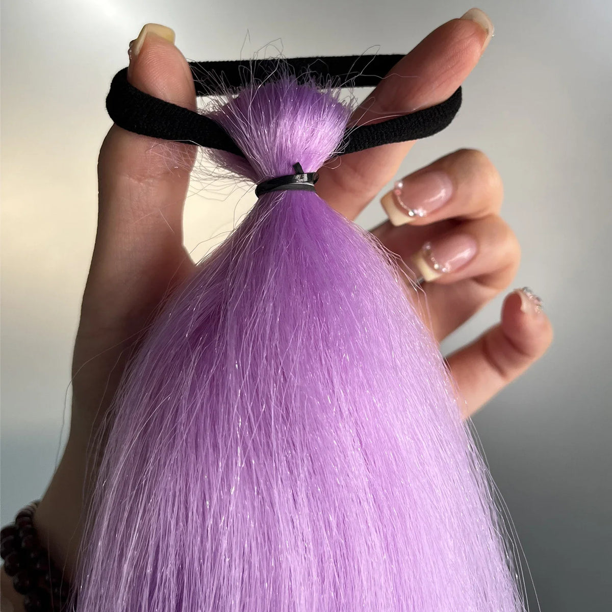 Purple synthetic ponytail extension with band from Corporación Turística, 26-28 inches long, styled for easy wear and natural look.