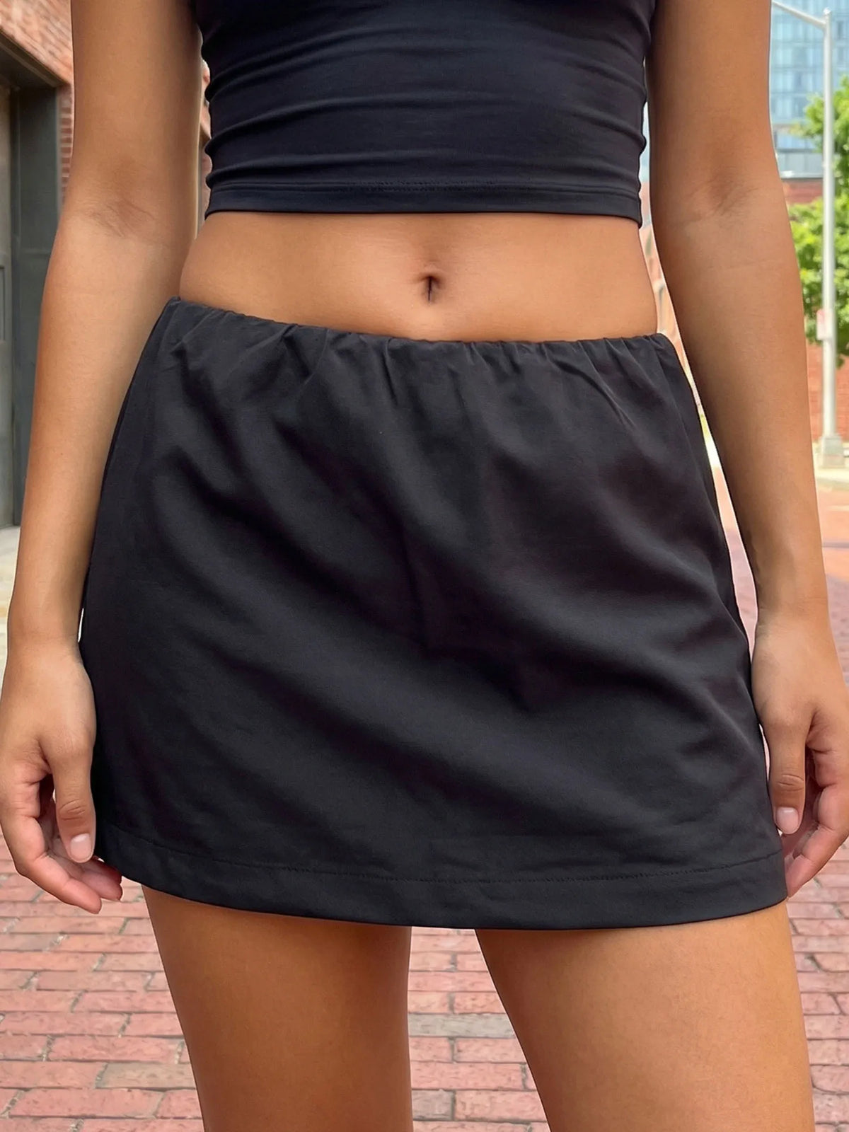 Low-waist pencil skirt for women, fitted style in brown fabric, by Corporación Turística, shown on a model.