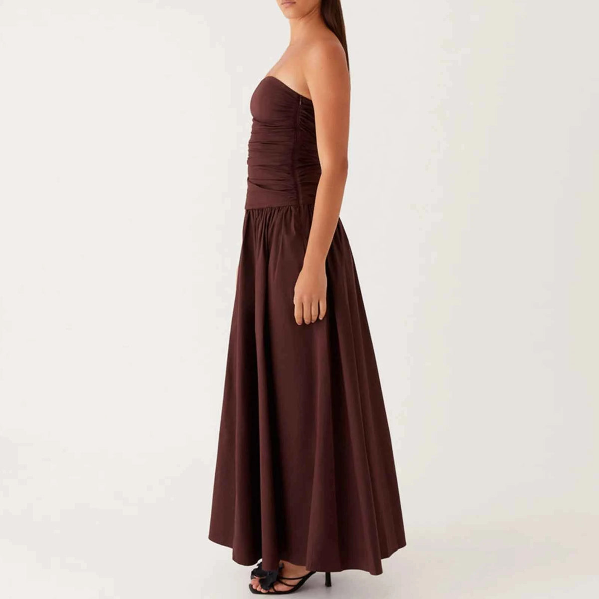 Elegant long sleeveless women's dress in beige from Corporación Turística, featuring a sleek V-neck design and flowing fabric.