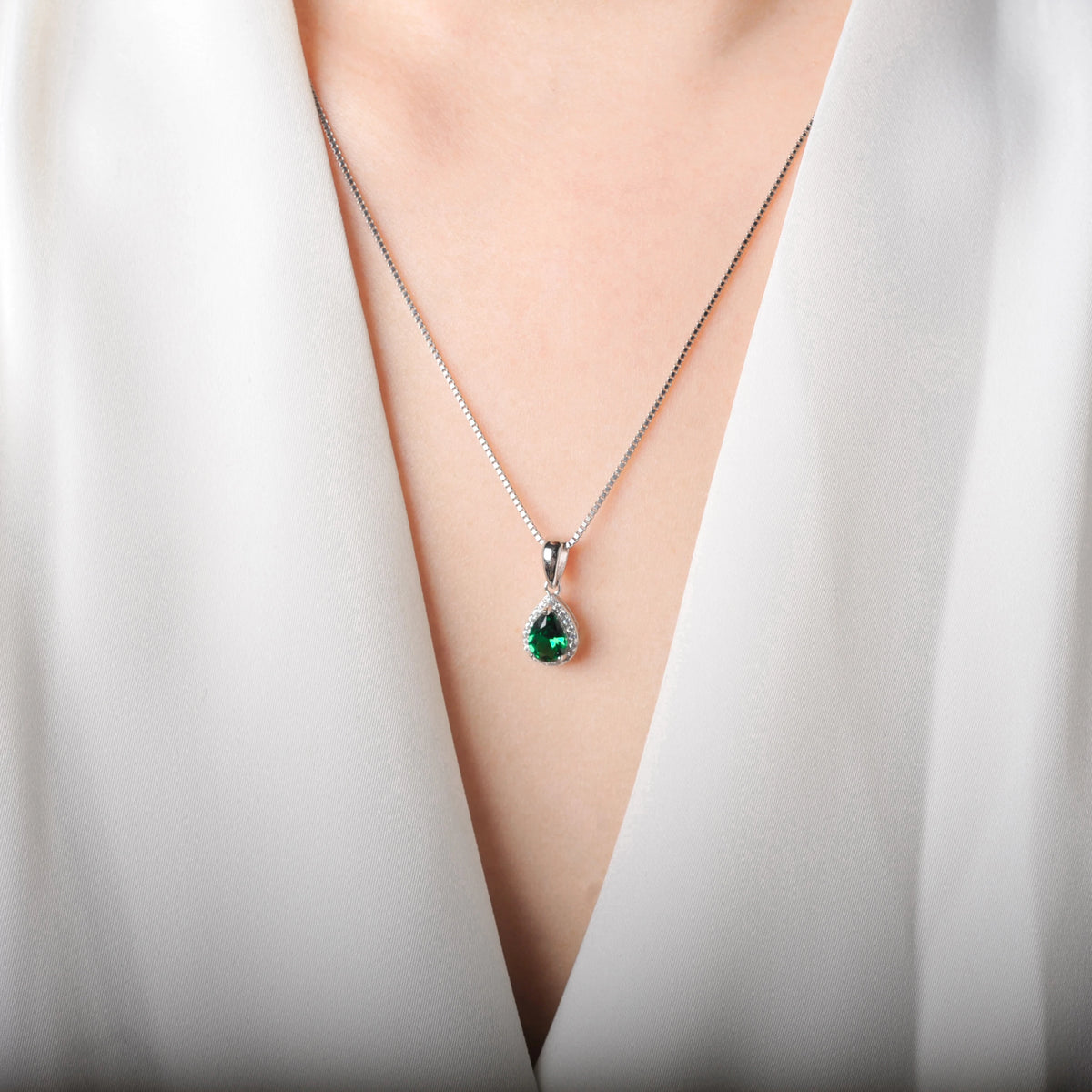 Sterling silver 925 necklace with emerald pendant, featuring a shiny rhodium-plated chain and intricate gemstone detail.
