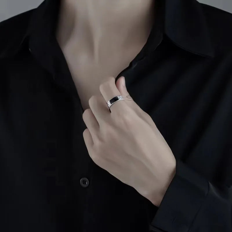 Sterling silver men's ring with black gemstone from Corporación Turística, featuring a sleek design and polished finish.