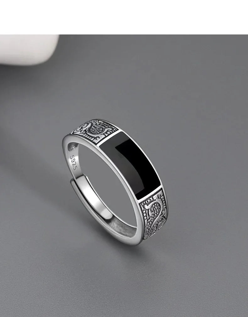 Sterling silver 925 men's ring with a black gemstone, featuring a sleek design and polished finish.