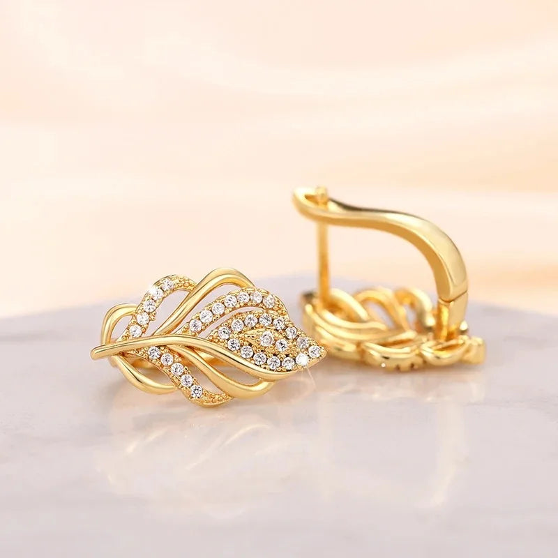 Hoop earrings Huitan in leaf shape with intricate design, made by Corporación Turística, hanging on display.