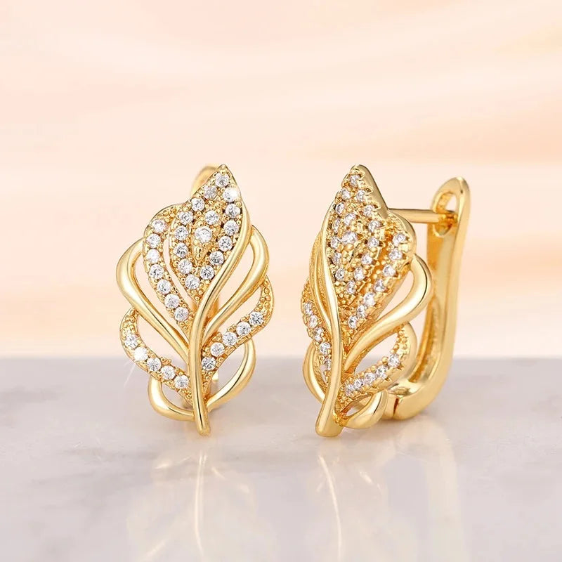 Huitan leaf-shaped hoop earrings from Corporación Turística, gold-tone jewelry with intricate leaf design.