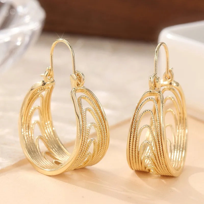 Gold dangling earrings for women with decorative patterns, featuring intricate designs and a shiny finish.