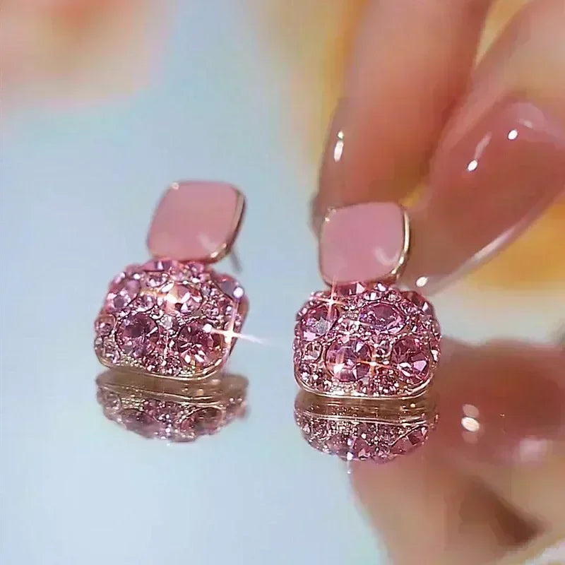 Square crystal zirconia earrings in brown from Corporación Turística, featuring sparkling geometric jewelry design.