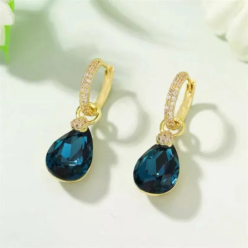 Exquisitos pendientes colgantes de cristal en forma de go con detalles elegantes, diseñados por Corporación Turística.
