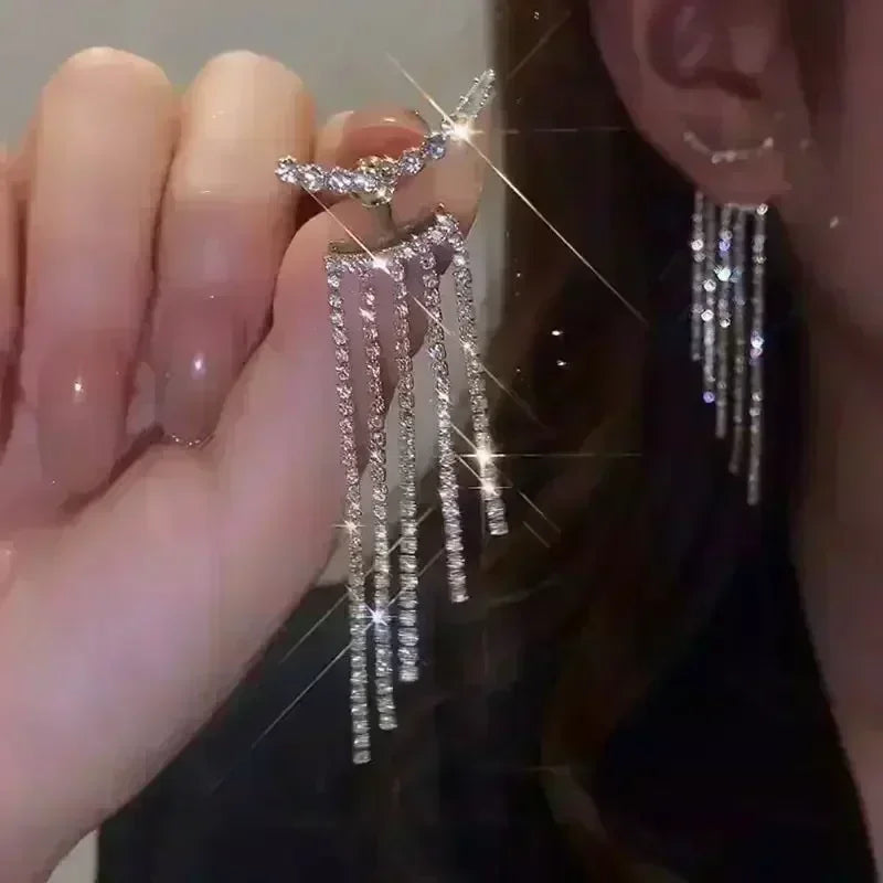 Exquisitos pendientes colgantes de cristal en forma de gotas, con detalles elegantes y transparentes, de la marca Corporación Turística.