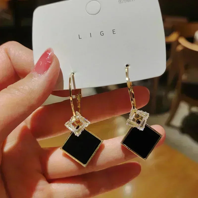 Exquisitos pendientes colgantes de cristal en forma de lágrima, en color blanco, diseñados por Corporación Turística.