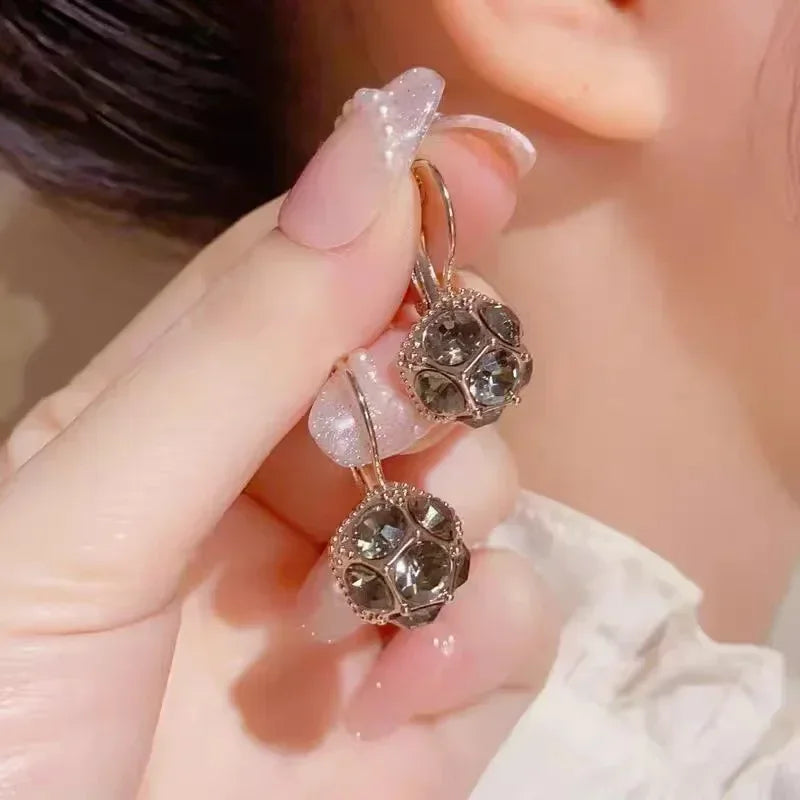 Elegant circular floral earrings by Corporación Turística featuring intricate flower designs and vibrant details.