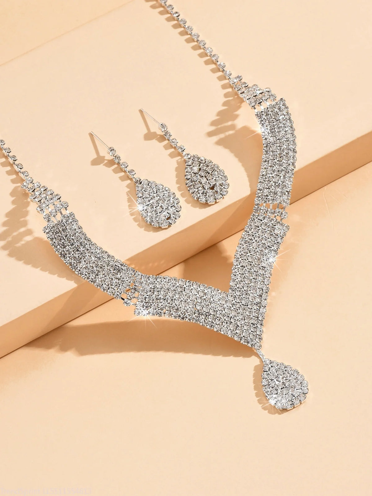 Fashion jewelry set with teardrop-shaped rhinestones in gold-tone by Corporación Turística, includes earrings and necklace.