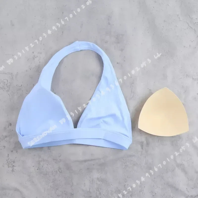 Light blue women's sports bra with halter neck design from Corporación Turística, shown on a white background.