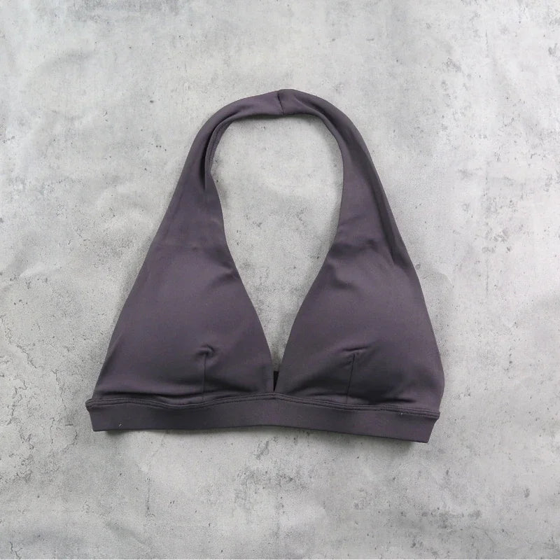 Light blue women's sports bra with halter neck design, by Corporación Turística, shown on a white background.