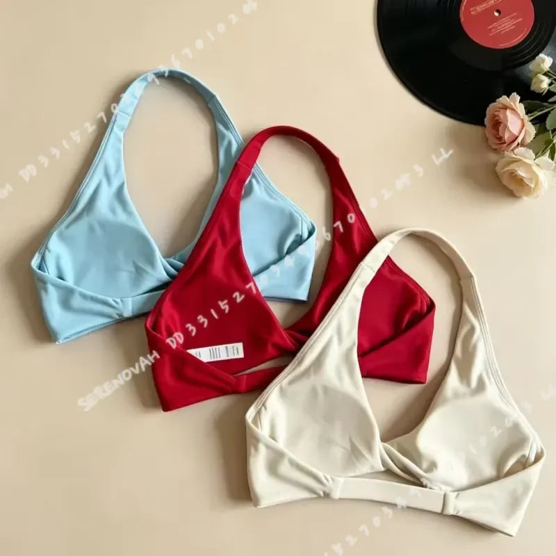 Scarlet red halter sports bra for women with open back, made by Corporación Turística, shown on a model.