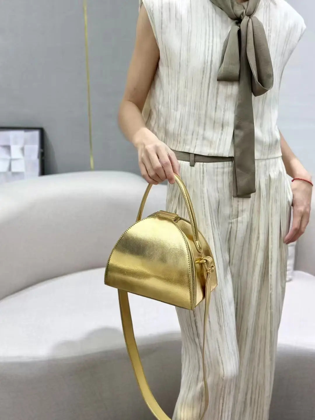 Gold PU shoulder bag for women with niche design, compact size, by Corporación Turística.