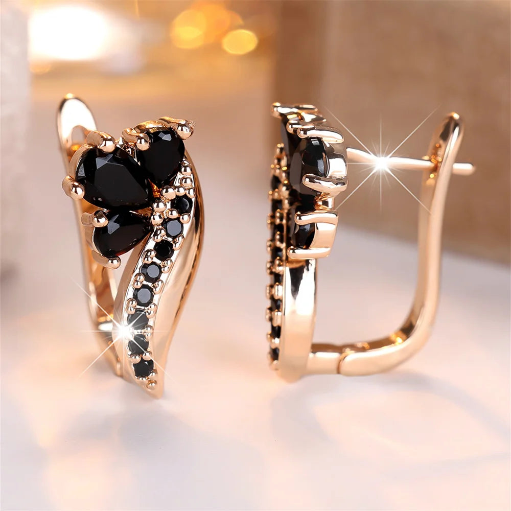 Gold and black hoop earrings with water drop-shaped crystal stones, stylish jewelry by Corporación Turística.