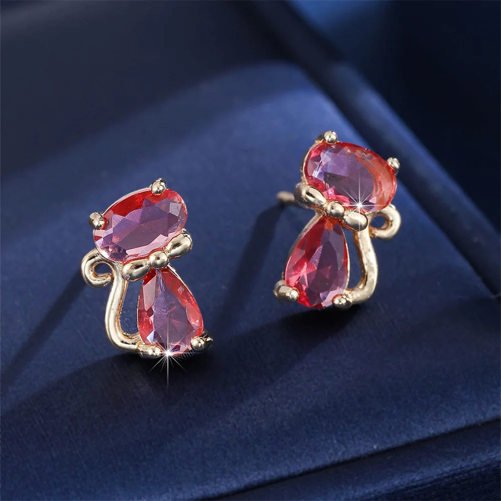 Small green cat-shaped earrings with zirconia stones, crafted by Corporación Turística, shown with gold-tone finish.