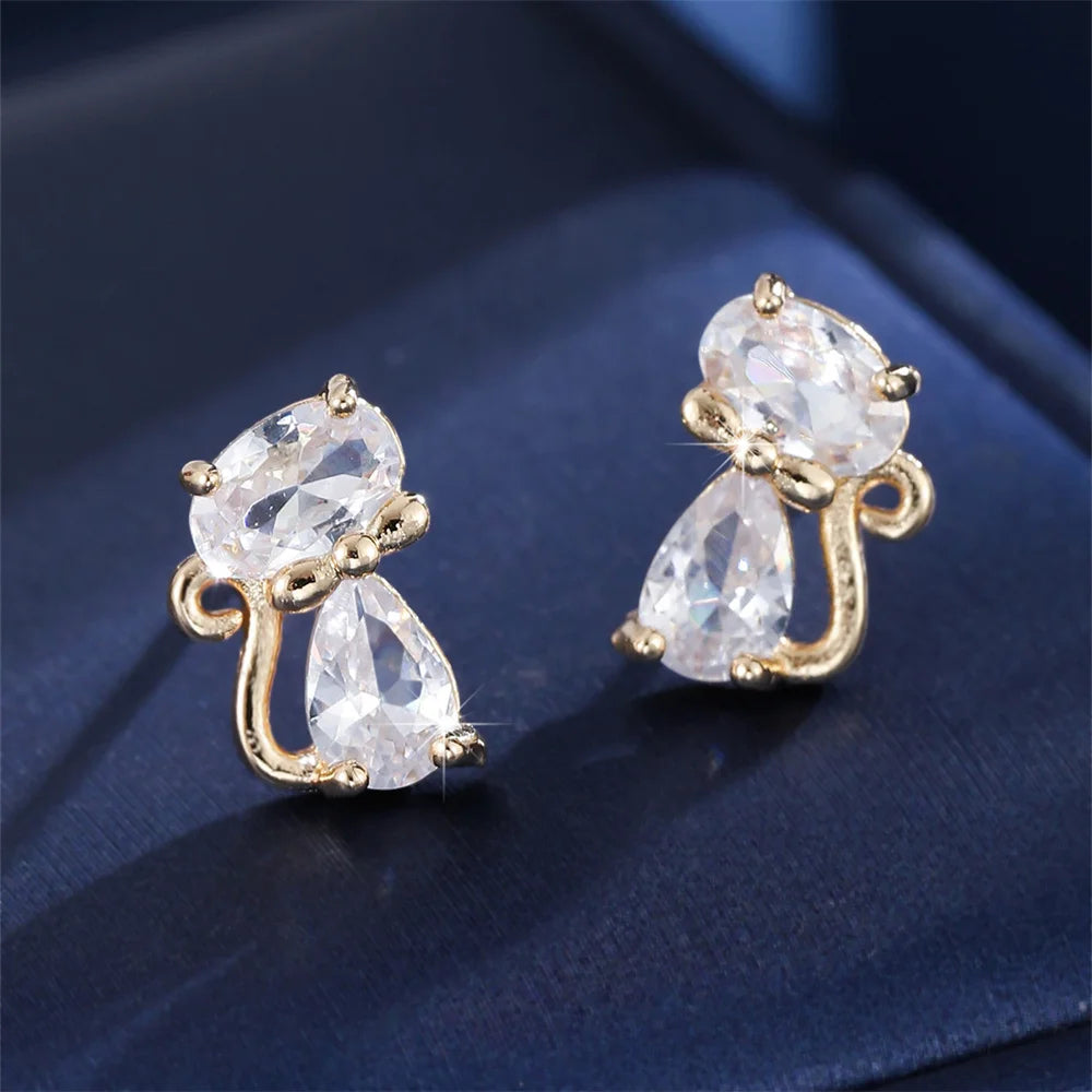 Small green cat-shaped earrings with zirconia stones, crafted by Corporación Turística, shown in a close-up image.