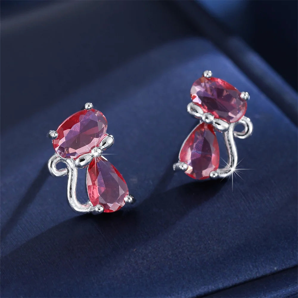 Small green cat-shaped earrings with zirconia stones from Corporación Turística, showcasing delicate jewelry craftsmanship.