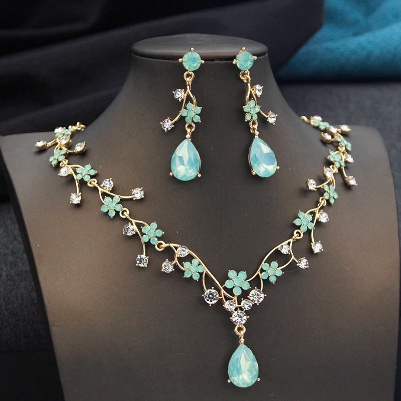 Gold and white water drop-shaped jewelry set for women by Corporación Turística, featuring earrings and necklace.