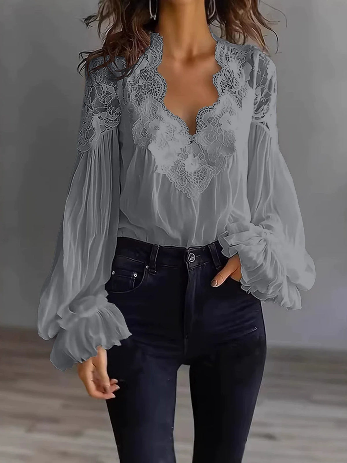 White lace blouse with deep V-neck and long sleeves, from Corporación Turística, shown on a hanger.