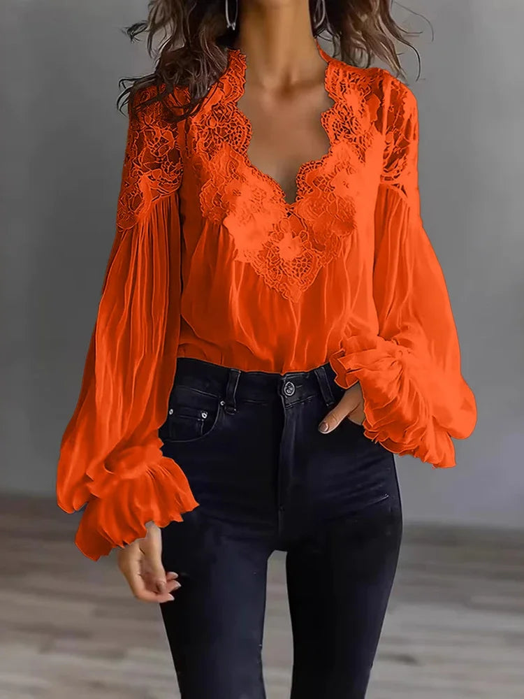White lace blouse with deep V-neck and long sleeves, from Corporación Turística, shown on a hanger.