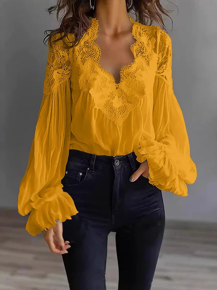 White lace blouse with deep V-neck and long sleeves, stylish shirt from Corporación Turística, shown on a hanger.