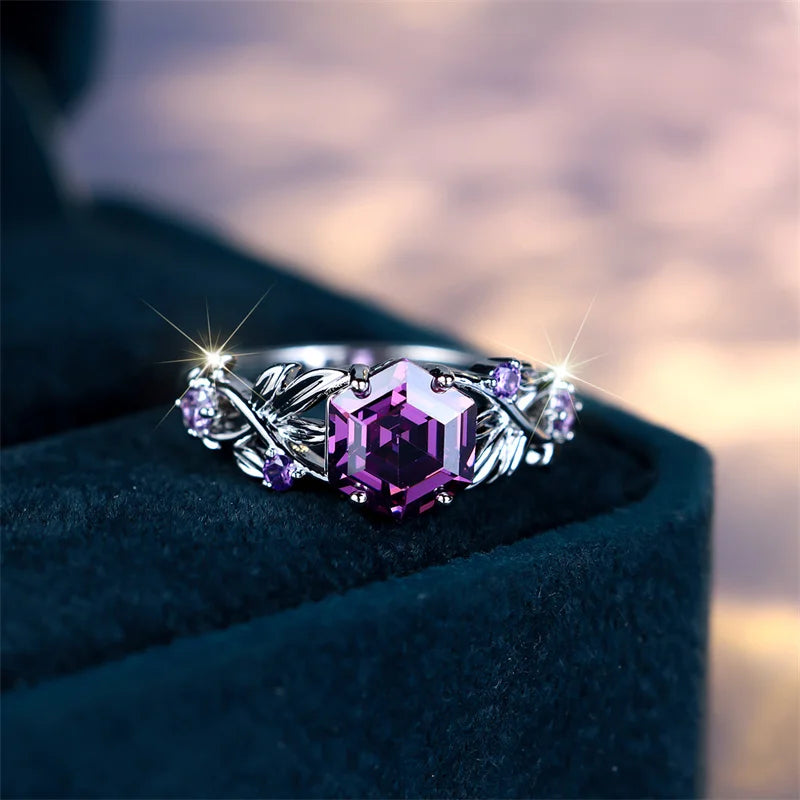Purple circular ring with a hexagonal zircon center and embedded stones, stylish jewelry by Corporación Turística.