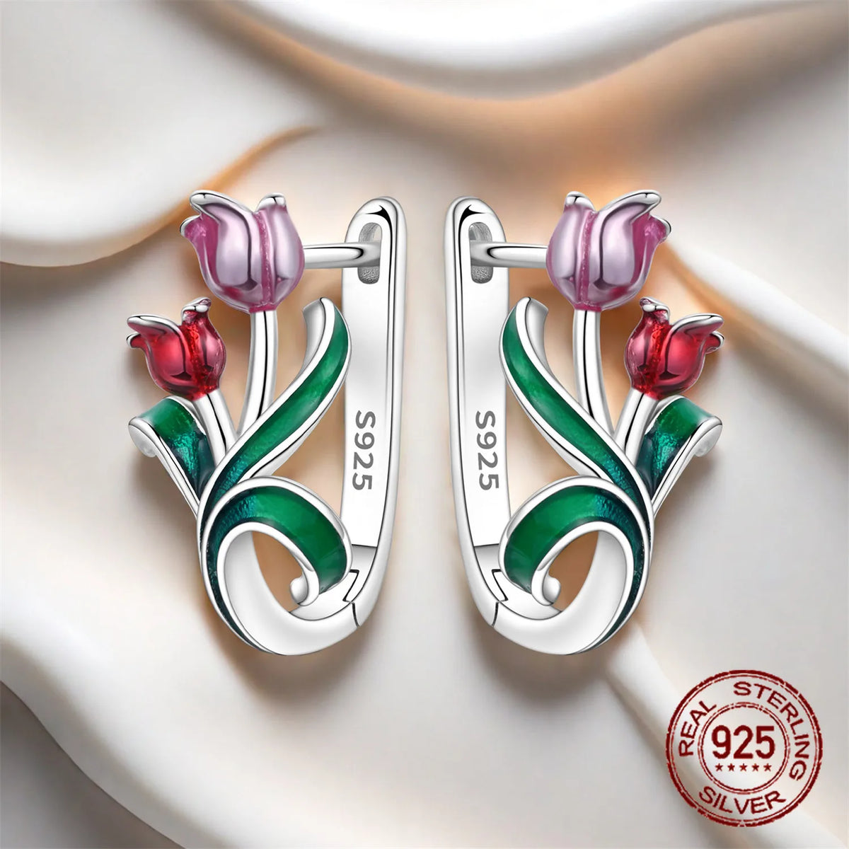 Silver hoop earrings with leaf and flower design, crafted by Corporación Turística, showcasing intricate botanical details.