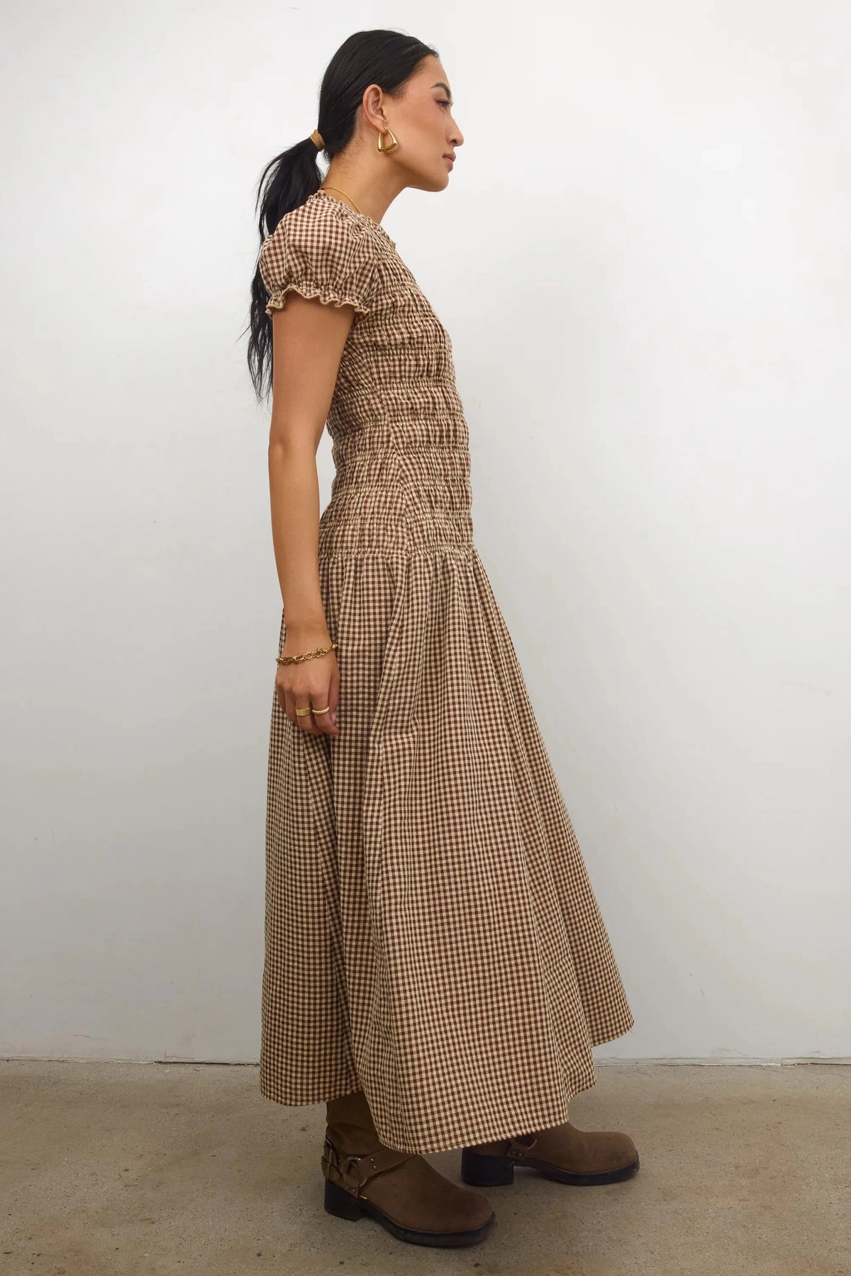 Elegant women's smocked dress with floral print in brown, featuring a stylish fit and comfortable design by Corporación Turística.