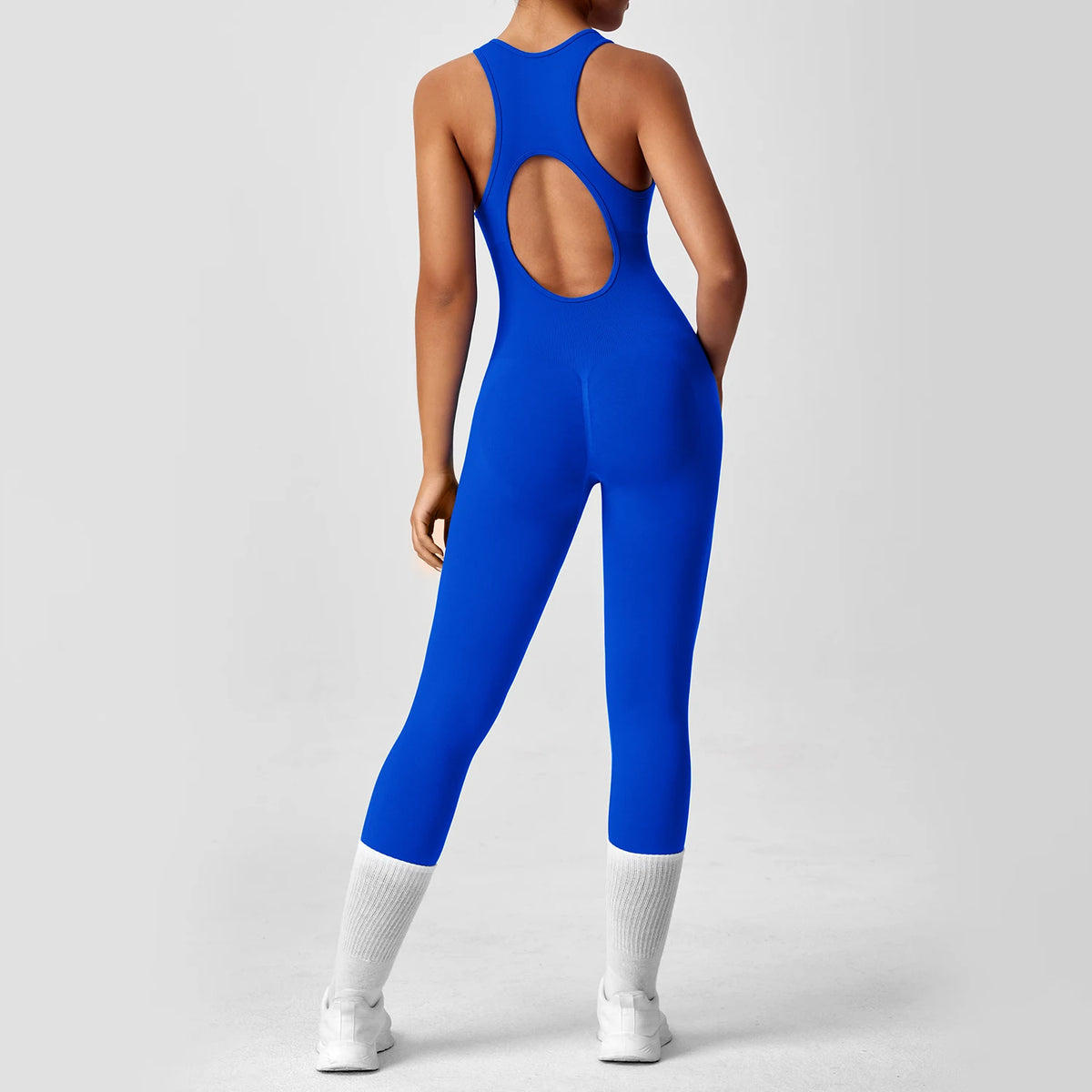 Orange peach-colored one-piece yoga bodysuit with matching boot, from Corporación Turística, displayed on a neutral background.