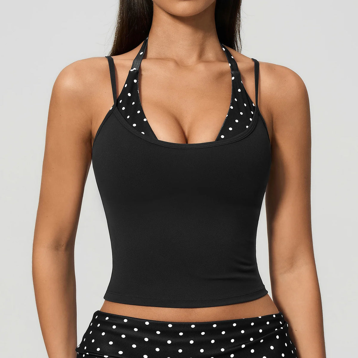 Striped yoga sports top with built-in anti-chock bra from Corporación Turística, shown in white with subtle dot pattern.