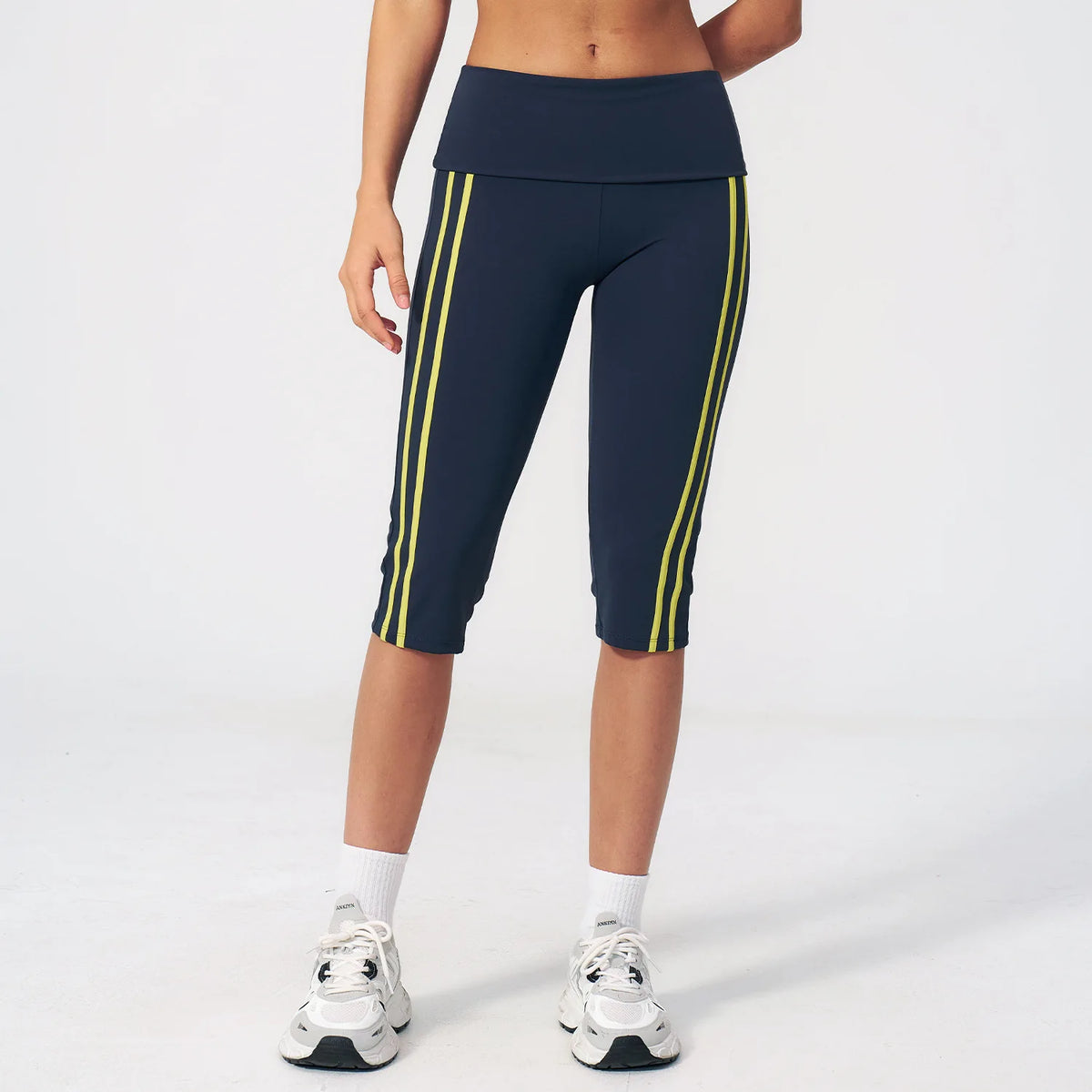 Moss green high-waist yoga capri leggings for women with a wide waistband, made by Corporación Turística, shown on a model.