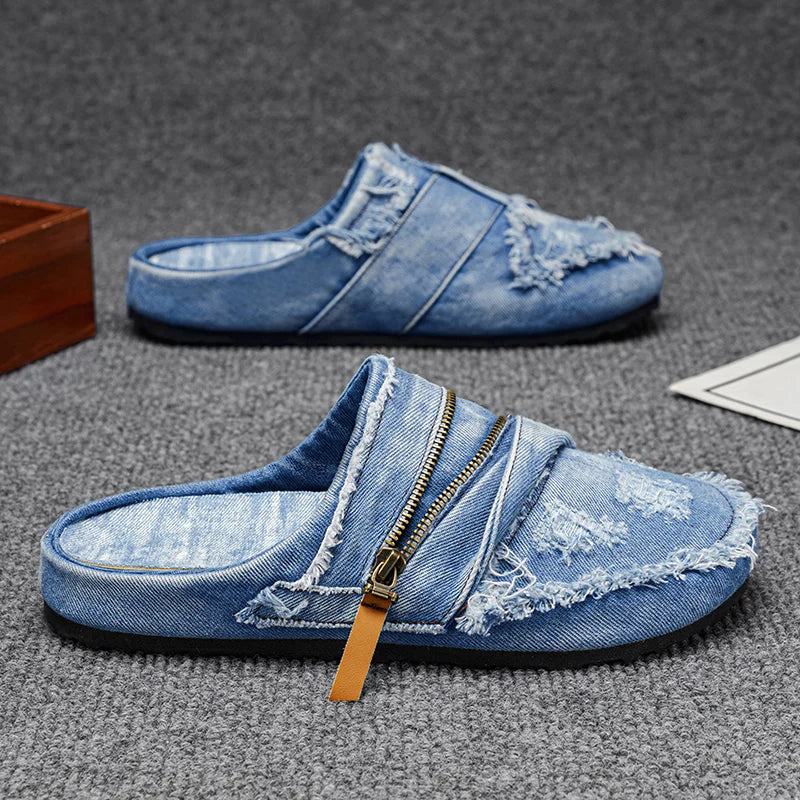 Blue denim mules with frayed edges from Corporación Turística, showcasing stylish casual footwear on a model.