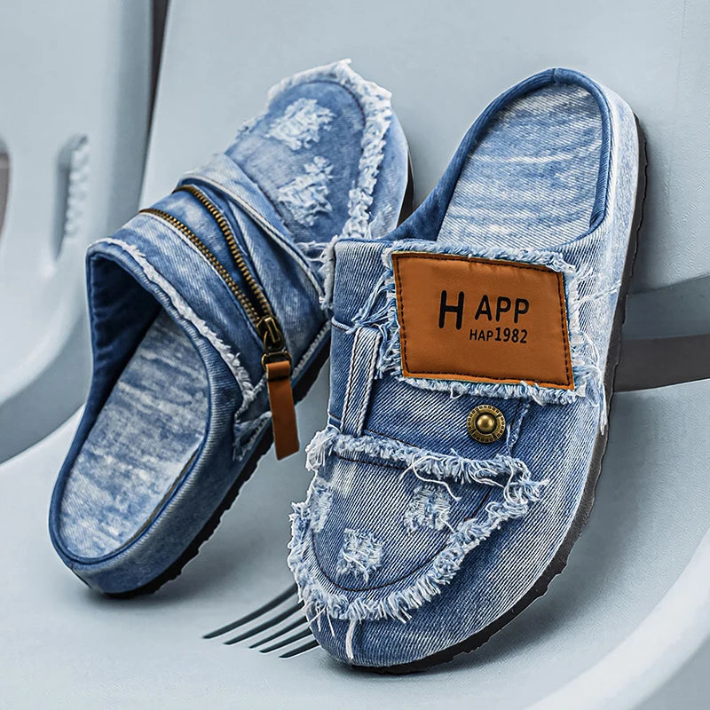 Light blue denim mules with frayed edges, casual slip-on footwear from Corporación Turística, shown on a neutral background.