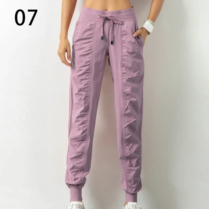 Navy blue women's athletic track pants with drawstring waist, made of soft fabric, ideal for running and casual wear.