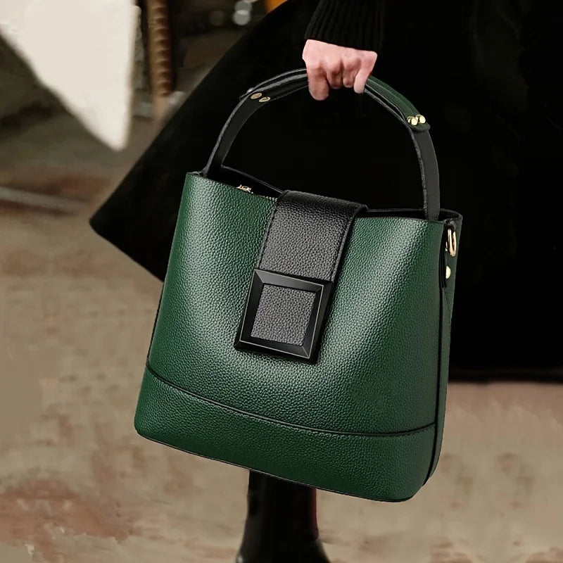 Black solid color bucket bag with adjustable shoulder strap, stylish and versatile design by Corporación Turística.