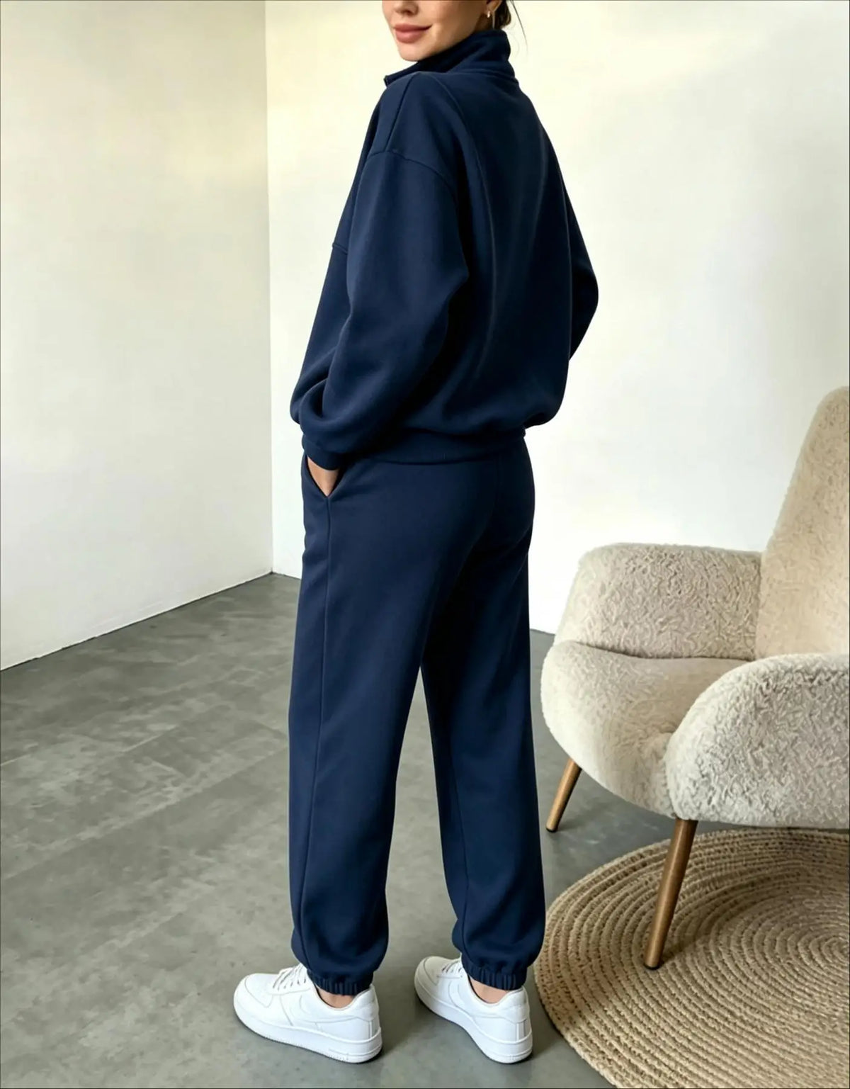 Black sweatshirt and pants set by Corporación Turística, featuring a half-zip sweatshirt and matching comfortable pants.