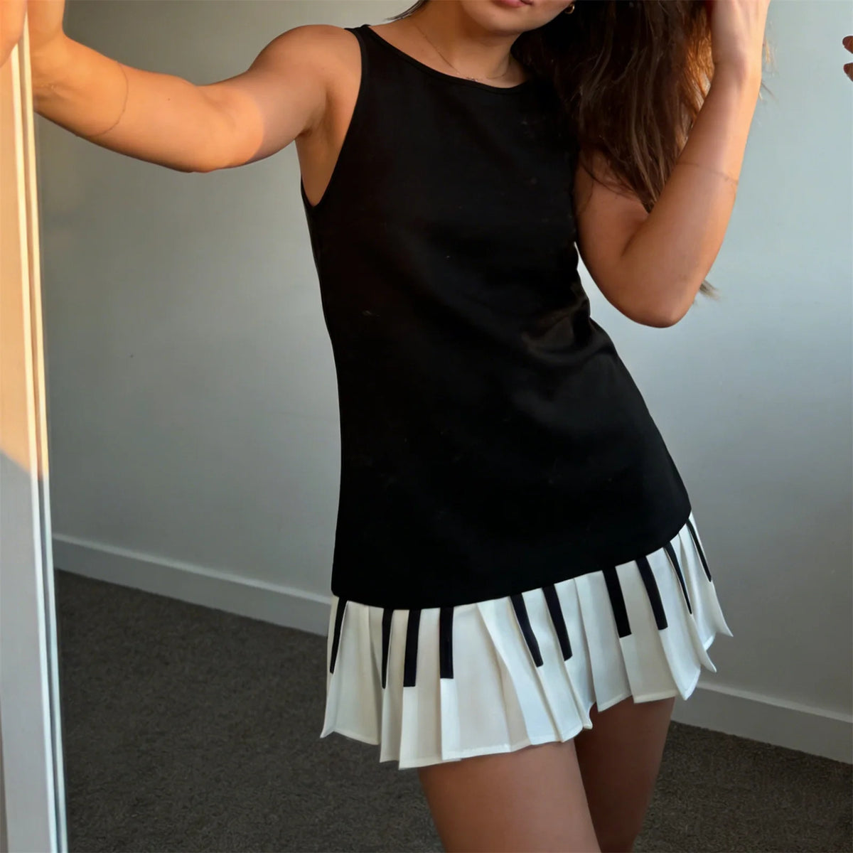 Black sleeveless women's dress by Corporación Turística featuring a fitted, pleated design for a stylish look.