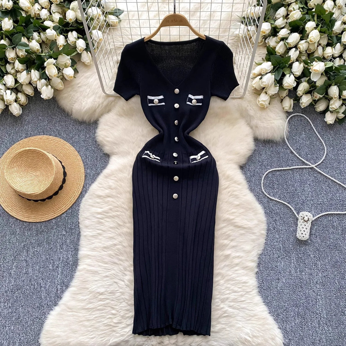 Black Yuoouoo knitted dress with V-neck and button, stretchy fabric, from Corporación Turística, featuring a fitted silhouette.